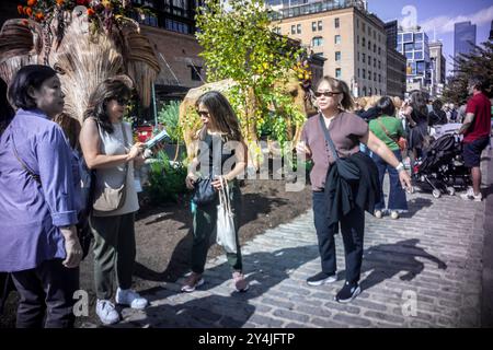 People are awed by the Great Elephant Migration public art installation in the Meatpacking District in New York on Sunday, September 8, 2024. The 100 statues were created by the Coexistence Collective whose mission helps people share space with natures magnificent creatures.The elephants were constructed by Indian indigenous artisans out of the Lantana camara, an invasive plant species. The installation will be on display until October 20. (© Richard B. Levine) Stock Photo