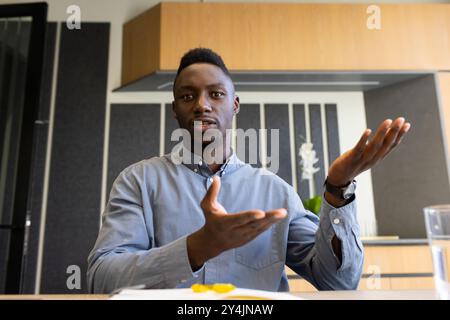Explaining business strategy, man gesturing during meeting in modern office Stock Photo