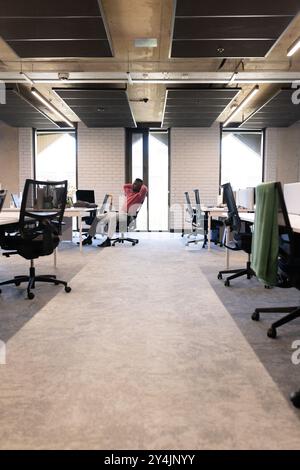 Relaxing in office, african american man leaning back in chair in modern workspace, copy space Stock Photo