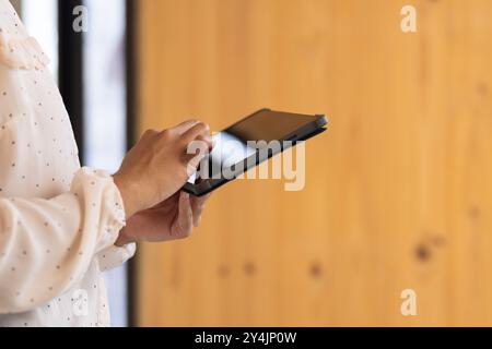 Using tablet, person working on business tasks in modern office setting Stock Photo