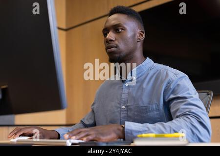 Working on desktop computer, man focusing on tasks in modern office Stock Photo