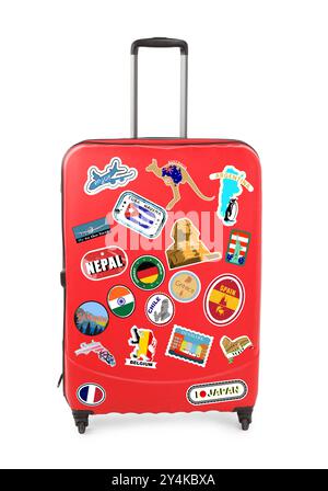 Stylish red suitcase with travel stickers isolated on white Stock Photo