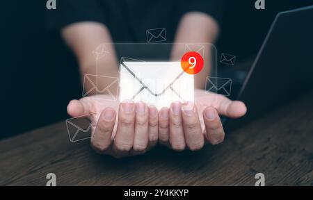 New email notification and online communication technology concept. Hand with mail with notifying alert for business e-mail and digital marketing. Inb Stock Photo