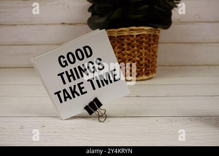 Good Things Take Time text message on sticky note on wooden background Stock Photo