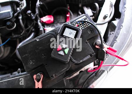 Car battery voltage testing with battery tester , Car battery maintenance concept Stock Photo