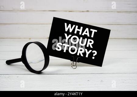 What's Your Story? text message on paper card with magnifying glass on wooden background Stock Photo