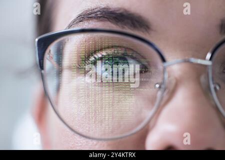 Closeup, portrait or woman with glasses and coding reflection for vision, eyes healthcare or wellness. Innovation, half face or programmer reading Stock Photo