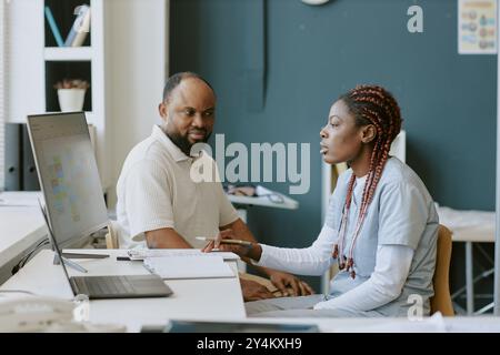 Discussing Project Goals in Modern Office Environment Stock Photo