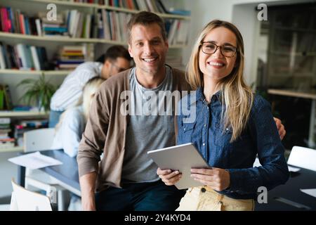 Two young businesspeople using a digital tablet while standing in a boardroom. Stock Photo