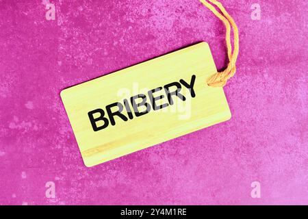 BRIBERY word written on the card on an abstract bright background Stock Photo