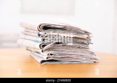 Stack of many newspapers on wooden table Stock Photo