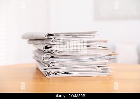 Stack of many newspapers on wooden table Stock Photo