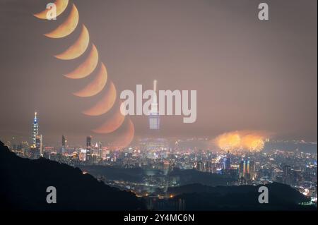 A breathtaking composite image of Taipei City skyline with fireworks and a lunar. The vibrant colors of the fireworks contrast beautifully with the se Stock Photo