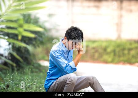 Young men in depression sitting alone in the park. Depressed and frustrated young men full of problems Stock Photo