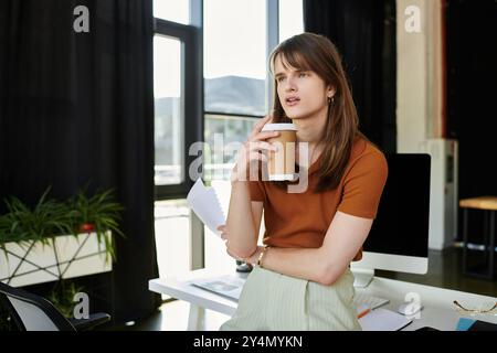 In a contemporary workspace, a non binary individual ponders over notes while savoring coffee. Stock Photo