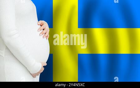 Swedish pregnant woman belly against Swedish flag background. Demographics and pregnancy in Sweden concept Stock Photo