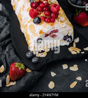 Meringue roll with cream and berries and almonds Stock Photo