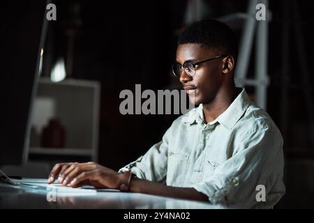 Night, man and serious in office, creative and video editing with software, planning and freelancer. Dark, entrepreneur and computer for content Stock Photo