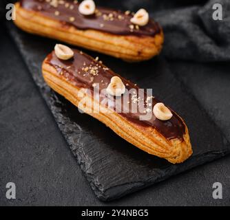 french eclairs with chocolate and hazelnuts Stock Photo