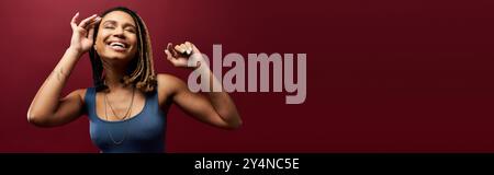 A young African American woman with braids expresses her vibrant personality while posing in a studio. Stock Photo