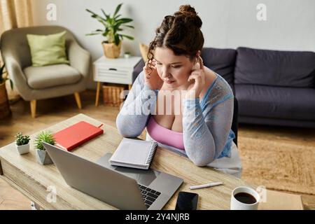 Lovely plus size woman with curly hair in cozy attire working at home. Stock Photo
