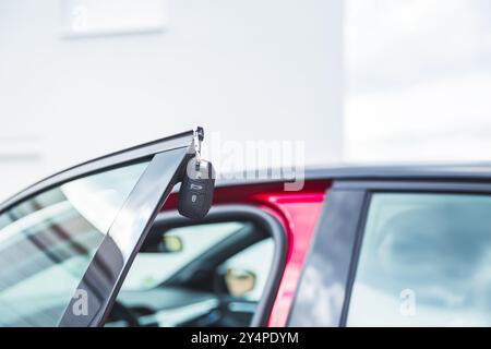 Car keys on open door - concept of bying or leasing new car Stock Photo