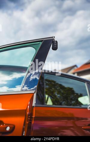 Car keys on open door - concept of bying or leasing new car Stock Photo