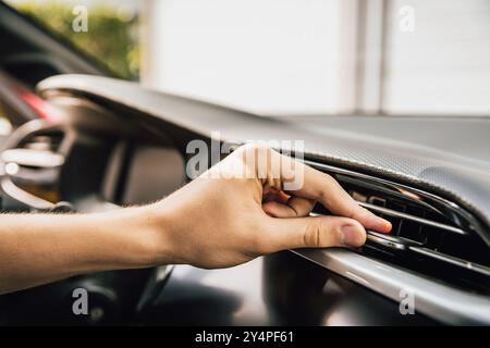 Hand adjusting air condition in a modern car Stock Photo