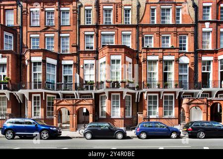 Explore the beautiful architecture of Victorian houses lining Pont Street in Kensington, showcasing their iconic red brick facades. Stock Photo