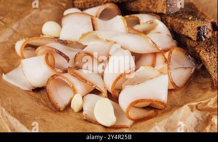 Ukrainian traditional food - sliced smoked lard on cutting board with garlic Stock Photo