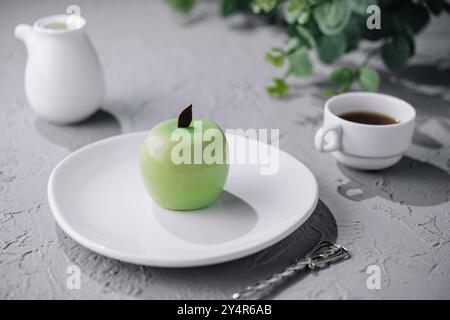 Green apple shaped mousse cake and cup of coffee Stock Photo