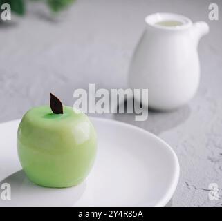 Green apple shaped mousse cake on plate Stock Photo