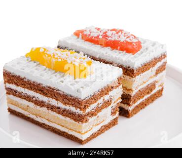 two slices of multilayer cocoa sponge cake with coconut flakes Stock Photo