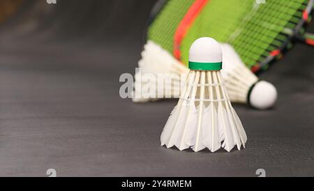 White badminton shuttlecocks and badminton rackets on dark background Stock Photo