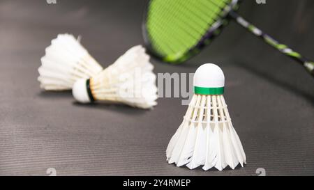 White badminton shuttlecocks and badminton rackets on dark background Stock Photo