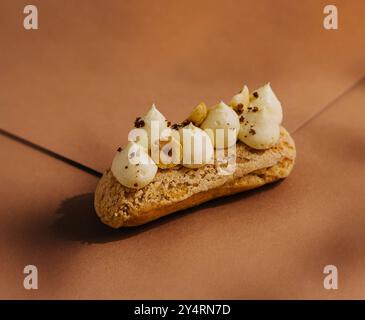 eclair with whipped cream and hazelnuts Stock Photo