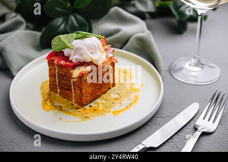 Elegant brunch setting featuring a savory toast topped with a delicate poached egg and drizzled with sauce Stock Photo