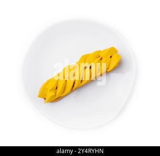 Vibrant mango eclair presented on a pure white circular plate, isolated on white background Stock Photo