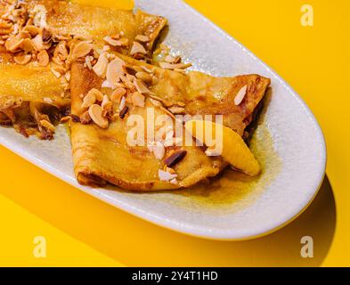 pancakes in honey syrup with mendal on yellow background Stock Photo