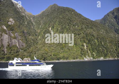 Milford Sound, New Zealand, circa 2009: Tourist Launch at Waterfall, Milford Sound, Fiordland, New Zealand, Oceania Stock Photo