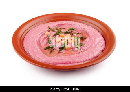 Pink beetroot hummus decorated with chickpeas and green onions, served on a clay dish, isolated on white background Stock Photo