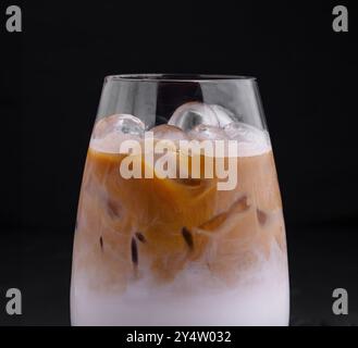 Iced coffee latte with milk and boba tapioca pearls is standing on black background Stock Photo