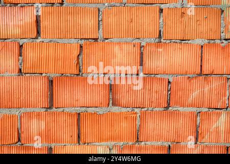 Abstract brick wall texture for the background. Roughly laid brick wall made of old cracked bricks. Stock Photo