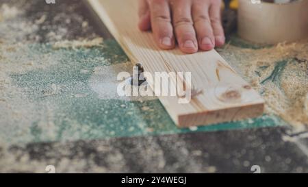 Close up of a carpenter working wood plank using electric milling machine in workshop Stock Photo