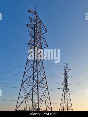 High voltage transmission towers stand tall against the blue sky in ...