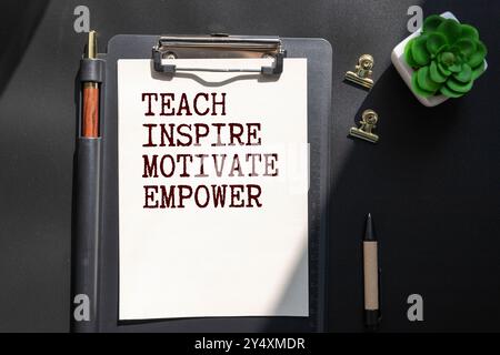 Business and economy concept. There are two notebooks and a pen on the table. On the top notepad, the inscription - Teach Inspire Motivate Stock Photo