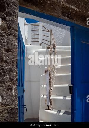 Abstract of whitewashed walls, blue door, steps and angles in Megalochori, Santorini, Greece. Stock Photo