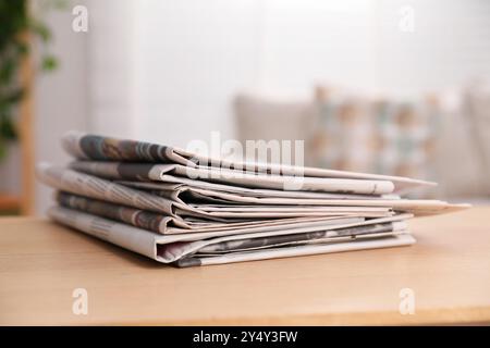Stack of newspapers in different languages on table indoors Stock Photo