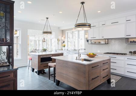Kitchen with two hickory islands and family room in background and small puppy Stock Photo