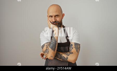Hispanic man with beard and tattoos wearing apron isolated over white background Stock Photo